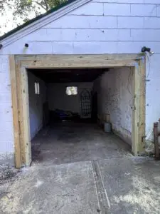 A open garage of a white house.