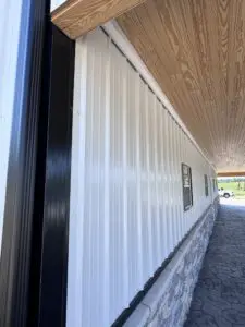 A white wall of a wooden house with windows